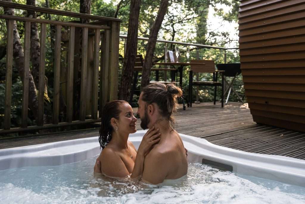 Couple in hot tub at RiverBeds Luxury Wee Lodges Romantic stay in Glencoe, Scotland.