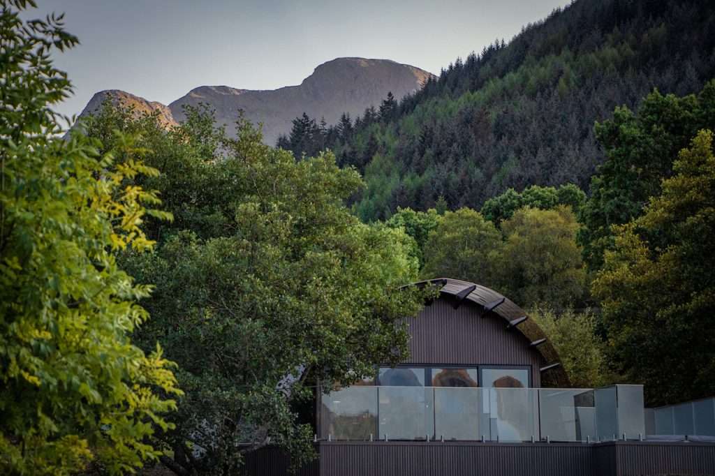 SeaBeds Luxury Lookout Lodge with Hot Tub at Woodlands Glencoe looking beautiful beneath the mountains and forest in mid summer.