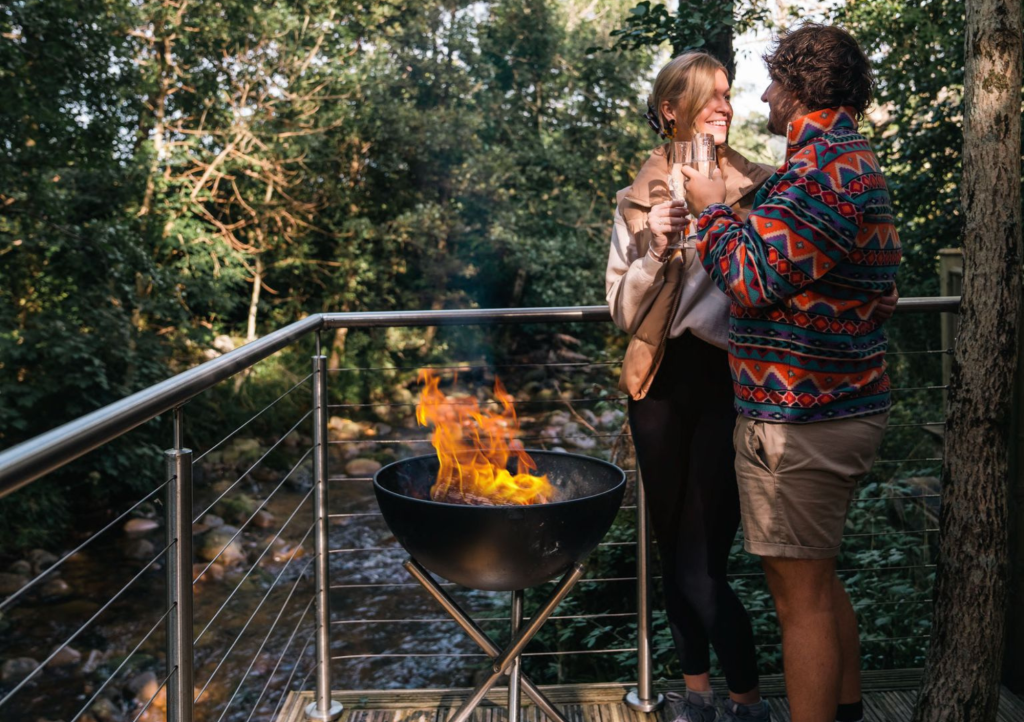 Couple reconnect on the terrace of RiverBeds Luxury Wee Lodges at Woodlands Glencoe.