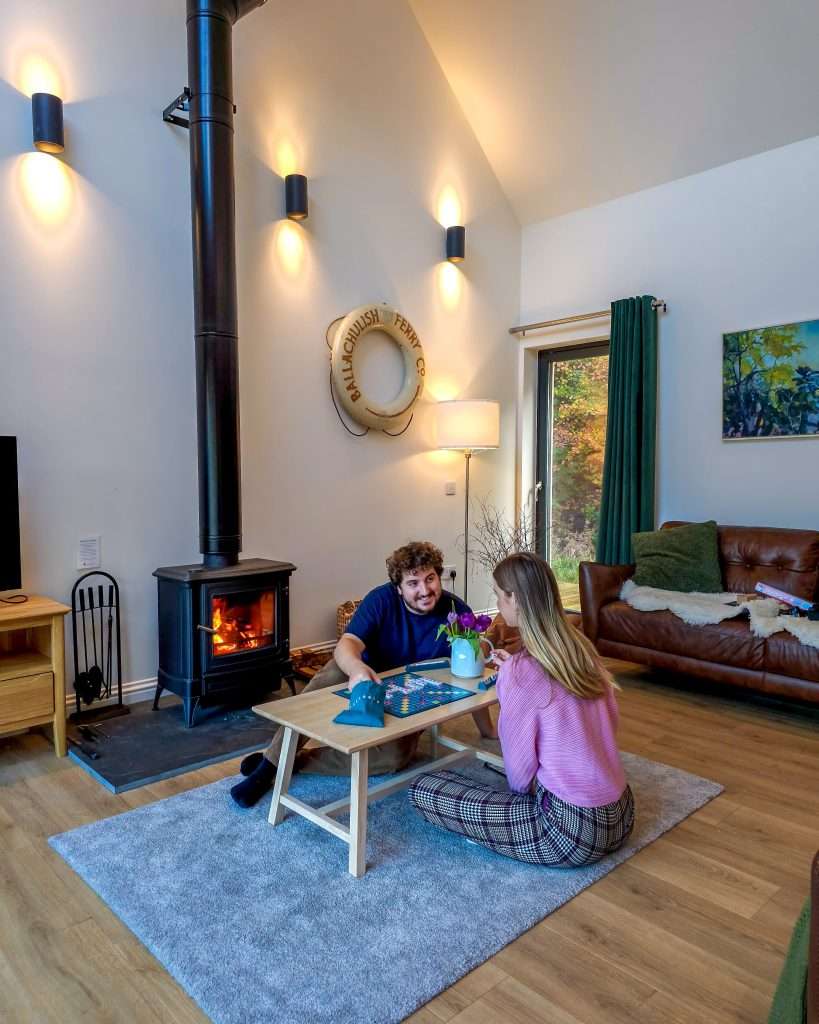 A couple play a boardgame at Forest Corner at Woodlands Glencoe as part of a digital detox in the Highlands.