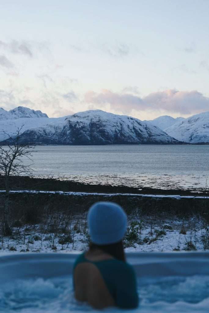 A lady hot tubs in the snow at Woodlands Glencoe