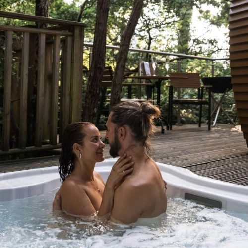 Couple in hot tub at RiverBeds Luxury Wee Lodges Romantic stay in Glencoe, Scotland.