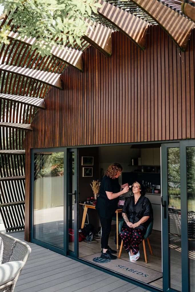 A bride to be has her wedding makeup applied at SeaBeds Luxury Lookout Lodges with Hot Tubs at Woodlands ahead of her Glencoe Elopement.