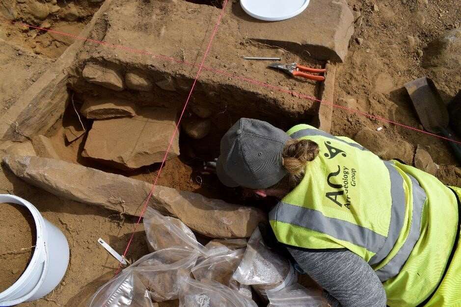 An archeologist digs out a burial cist in Drumnadrochit in the Highlands.
