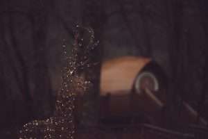 A fairy-lit reindeer sits outside RiverBeds Luxury Wee Lodges at Christmas in Glencoe