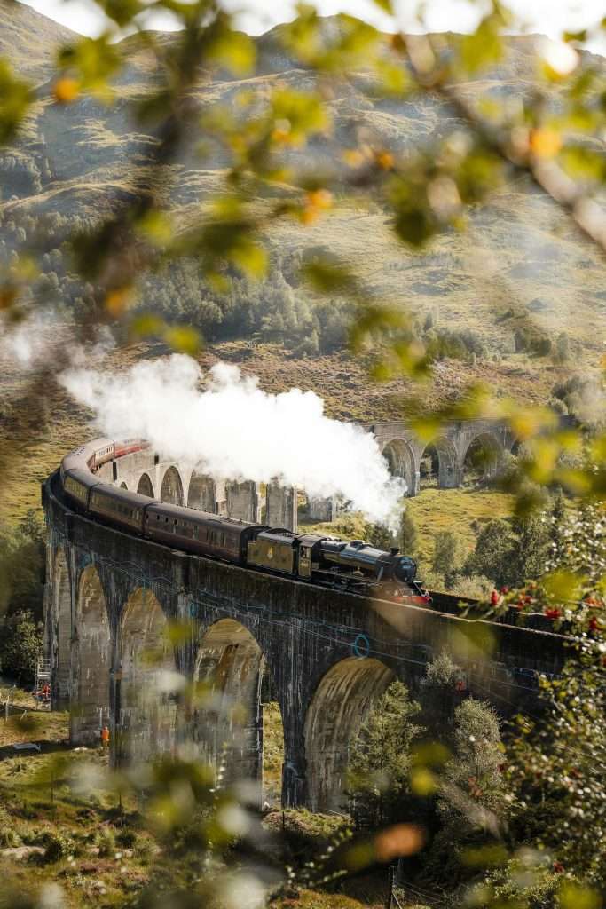 The Jacobite Steam Train or Hogwarts Express goes over Glenfinnan Viaduct.