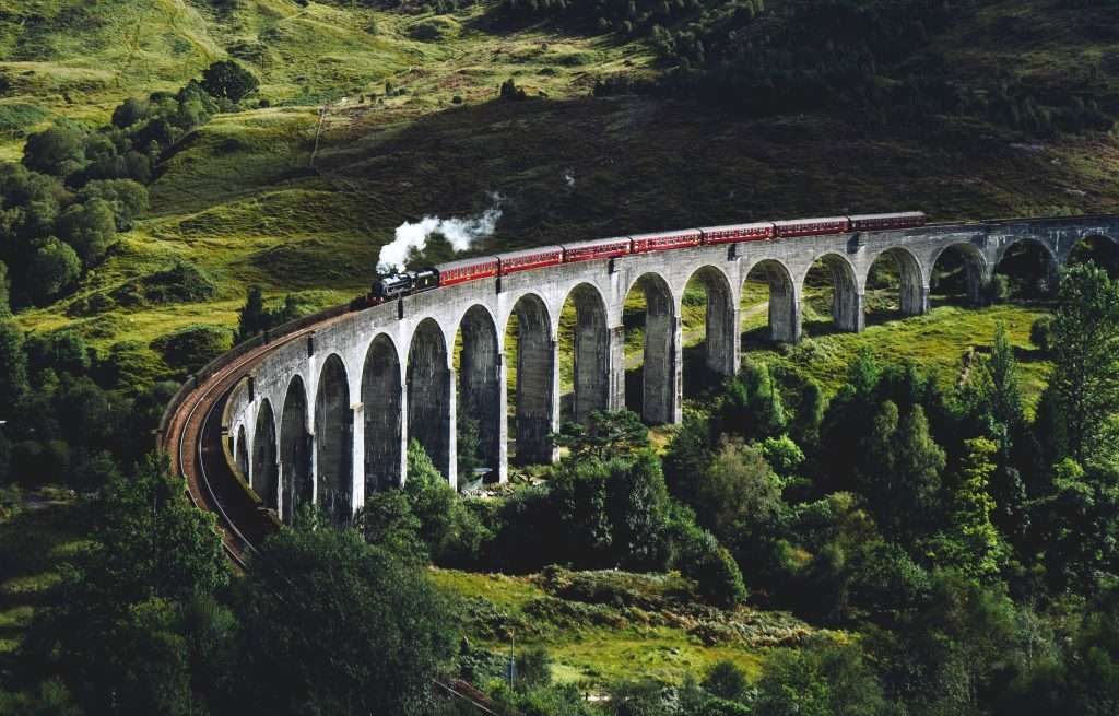 The Jacobite Steam Train or Hogwarts Express goes over Glenfinnan Viaduct.