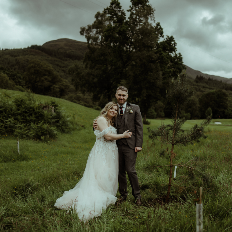 A newlywed couple looking very happy after planting their ceremonial tree on the Woodlands Estate in Glencoe.