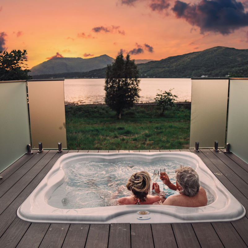 A couple enjoy the sunset over Loch Linnhe at SeaBeds Luxury Lookouts.