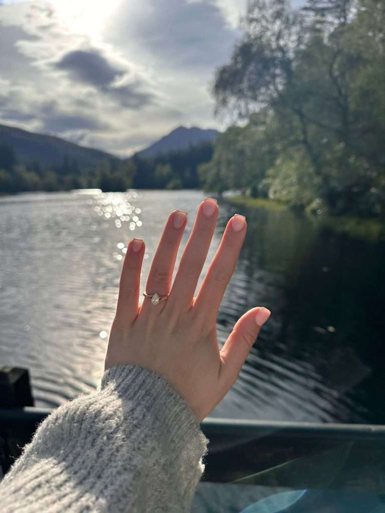 A lady shows off her brand new engagement ring on the banks of Glencoe Lochan.