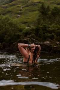 A lady comes up for air after a river swim in the River Etive.