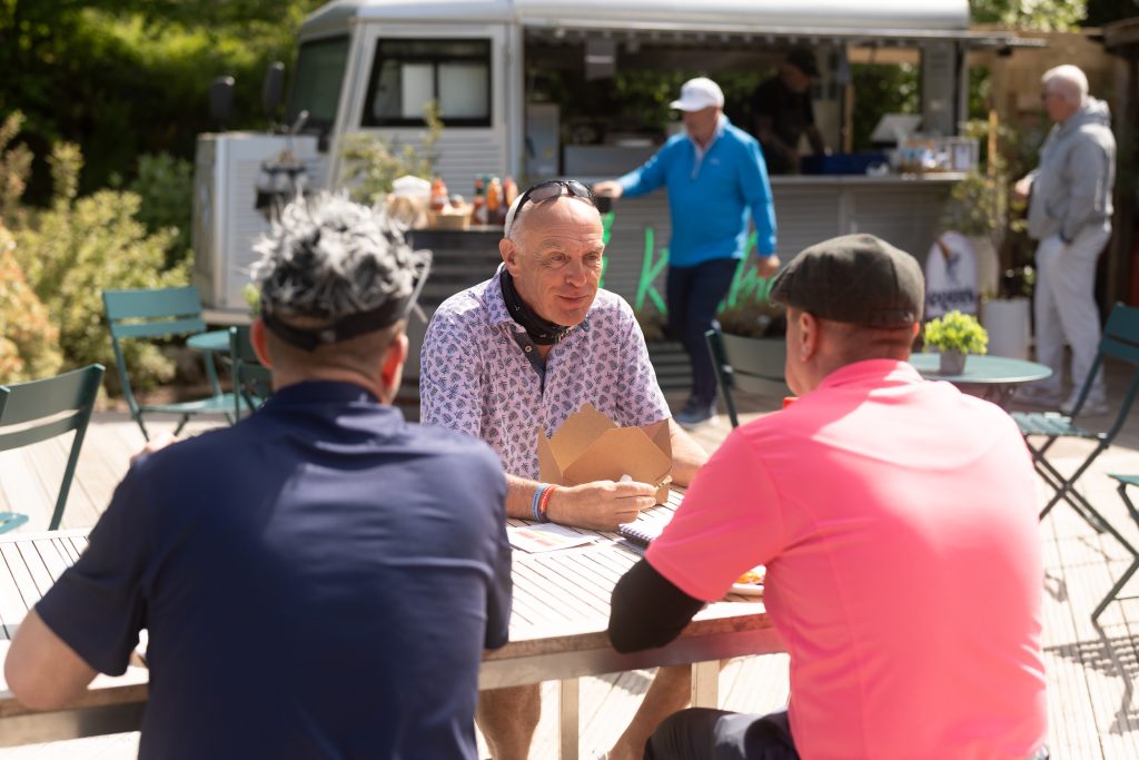 Three men enjoy a burger at Kitchen Food Truck at Woodlands Glencoe