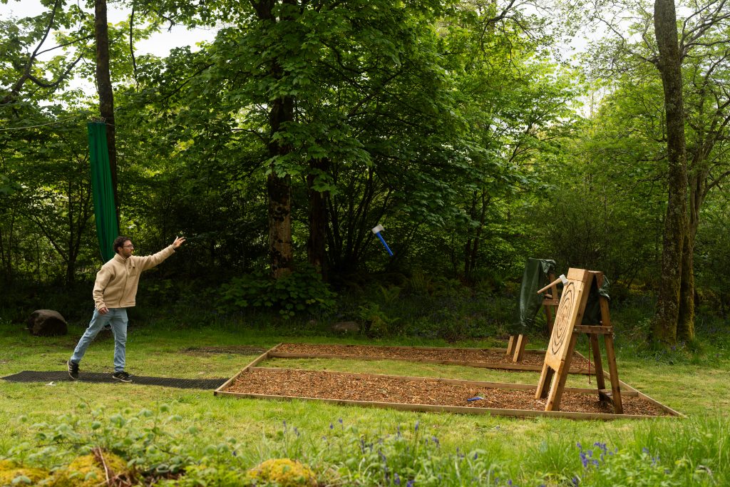 A man enjoys an axe throwing session at woodlands activity centre in glencoe.